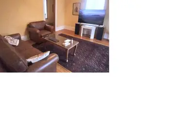 a living room with a couch and a table at Century House on Quarter acre lot in Acton