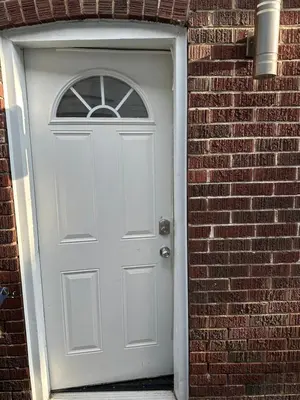 a white door in a brick wall at Toronto Upper Beaches Apartment in Toronto
