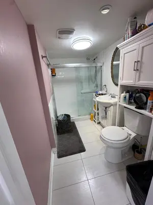 a bathroom with a shower and a toilet and a sink at Toronto Upper Beaches Apartment in Toronto