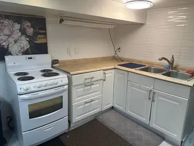 a kitchen with a white stove and a sink at Toronto Upper Beaches Apartment in Toronto