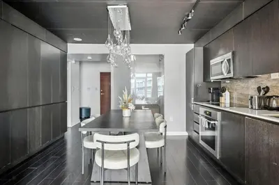 a kitchen with a table and some chairs in it at Stylish DT Condo with Vanity Mirror, Free Parking! in Toronto