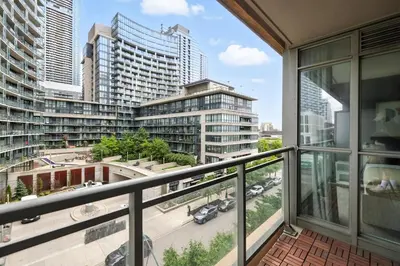 a balcony with a view of a city with tall buildings at Stylish DT Condo with Vanity Mirror, Free Parking! in Toronto
