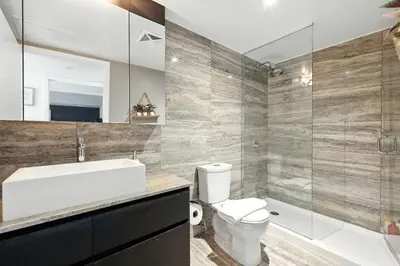 a bathroom with a toilet and a sink and a shower at Stylish DT Condo with Vanity Mirror, Free Parking! in Toronto