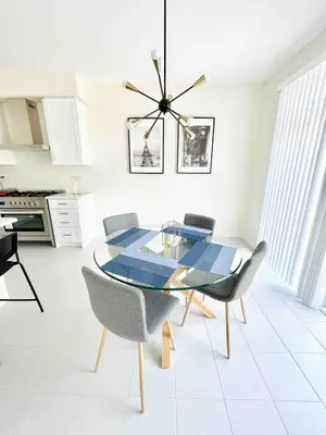 a dining room with a glass table and chairs at Two Adjacent Modern Homes in West Niagara Sleep 16 in Thorold