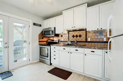 a kitchen with white cabinets and a stove top oven at Winter Family Retreat-Snow Play & Ski Hills Nearby in Barrie