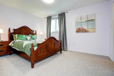 a bedroom with a wooden bed and a window at Winter Family Retreat-Snow Play & Ski Hills Nearby in Barrie