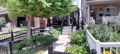 a porch of a house with a white fence at The Cozy Bungalow in North York Nest in Toronto