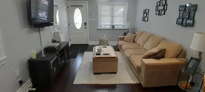 a living room with a couch and a tv at The Cozy Bungalow in North York Nest in Toronto
