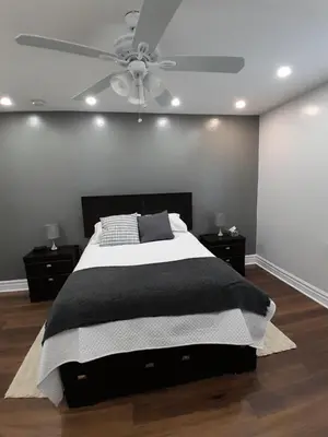 a bedroom with a bed and a ceiling fan at The Cozy Bungalow in North York Nest in Toronto