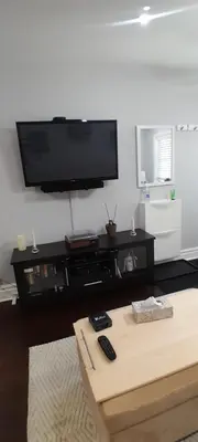 a living room with a flat screen tv on a wall at The Cozy Bungalow in North York Nest in Toronto