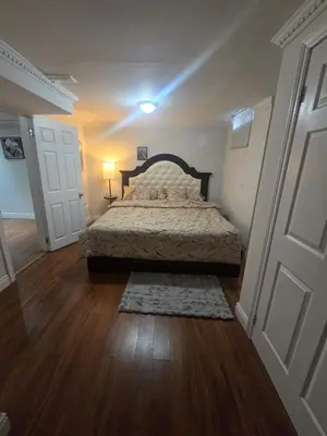a bedroom with a bed with a wooden floor at Private in Mississauga