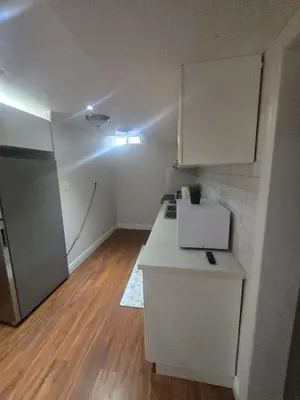 a kitchen with a white counter and a refrigerator at Private in Mississauga