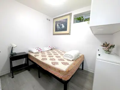 a small room with a bed and a table at Bright & New 2 Beds Near Subway in Toronto