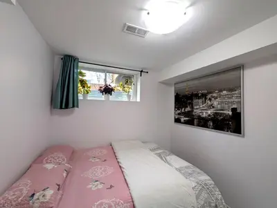 a small bedroom with a bed and a window at Bright & New 2 Beds Near Subway in Toronto