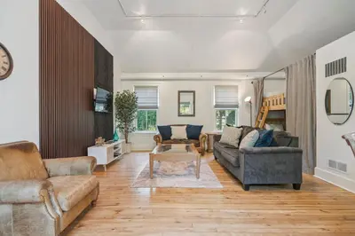 a living room with two couches and a table at Niagara on the Lake Walkable Old Town Retreat in Niagara on the Lake