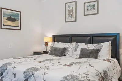 a bedroom with a large bed with a white bedspread at Niagara on the Lake Walkable Old Town Retreat in Niagara on the Lake