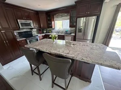 a kitchen with a marble counter top and a island at Hot Tub BANYA Sauna True Cottage experience in Innisfil