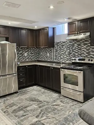 a kitchen with wooden cabinets and stainless steel appliances at 1 BR Bsmt, Sep Entrn, Fre Prkn, Wi-Fi, Ktchn, Lndry in Mississauga