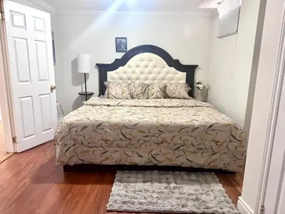 a bedroom with a large bed with a large headboard at Quincy Home in Mississauga