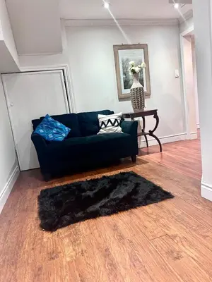 a living room with a blue couch and a table at Quincy Home in Mississauga
