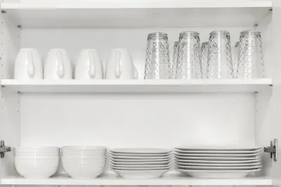 a shelf with plates and cups on it at SkyView 2BR Plus Den Stunning Views Steps to SQ1 Mall in Mississauga