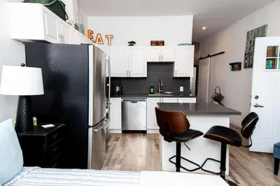 a kitchen with a black refrigerator and a table and chairs at Dundas and Brock Suitel in Toronto