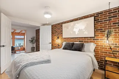 a bedroom with a brick wall and a bed at Waterfront Casa in wine County with SAUNA and HOT TUB in Demorestville