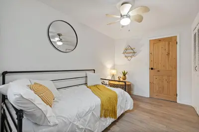 a bedroom with a bed with a ceiling fan and a mirror at Waterfront Casa in wine County with SAUNA and HOT TUB in Demorestville