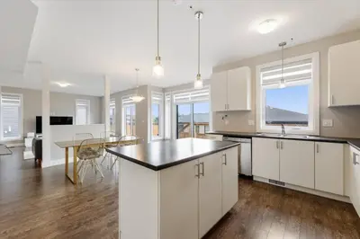 an open kitchen with white cabinets and a table at Relaxing Retreat Office, Patio, Nature and Netflix in Colborne