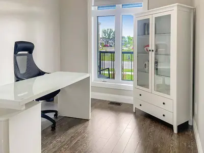a white desk with a chair and a glass cabinet at Relaxing Retreat Office, Patio, Nature and Netflix in Colborne