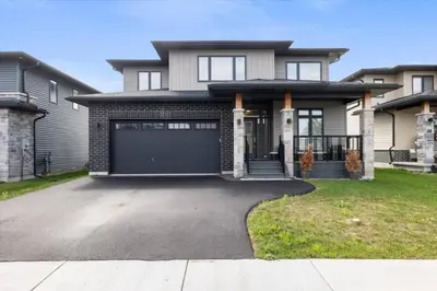 a house with a garage and a driveway at Relaxing Retreat Office, Patio, Nature and Netflix in Colborne