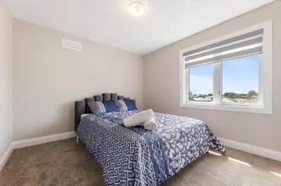 a bedroom with a bed and a window at Relaxing Retreat Office, Patio, Nature and Netflix in Colborne