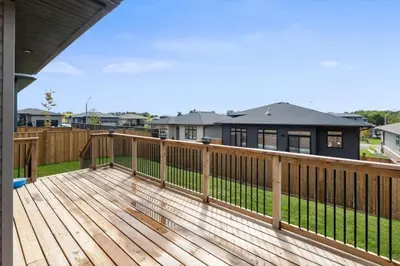 a wooden deck with a fence and a house at Relaxing Retreat Office, Patio, Nature and Netflix in Colborne
