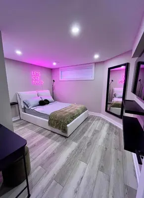 a bedroom with a bed and a pink wall at Modern Suite in Etobicoke - Near Airport & Downtown! in Toronto