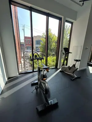 a gym with three exercise bikes in a room with large windows at Vibrant 1 Bedroom Condo Apt in Toronto