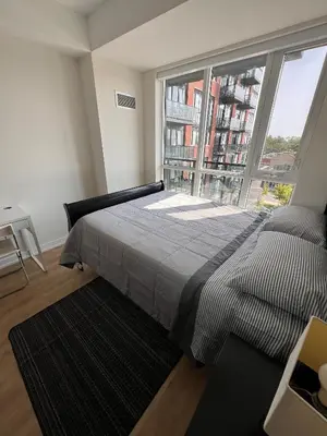 a bedroom with a bed and a large window at Vibrant 1 Bedroom Condo Apt in Toronto
