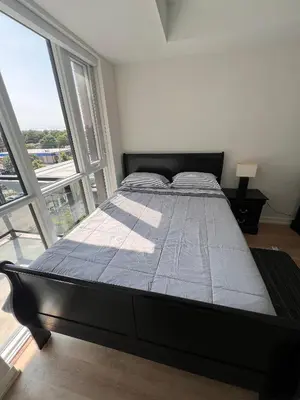 a large bed in a room with a large window at Vibrant 1 Bedroom Condo Apt in Toronto