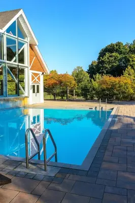 a swimming pool in front of a house at King Bed Suite with Pool and Hot Tub Access in Shanty Bay