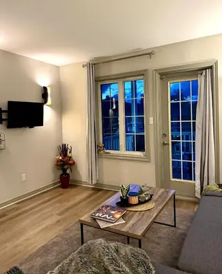 a living room with a coffee table and two windows at King Bed Suite with Pool and Hot Tub Access in Shanty Bay