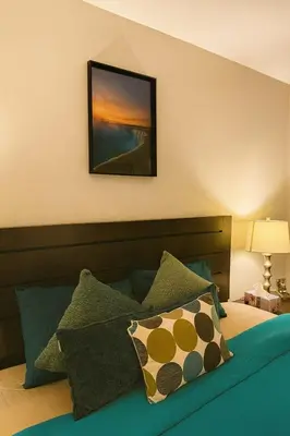 a bedroom with a bed with a picture on the wall at King Bed Suite with Pool and Hot Tub Access in Shanty Bay