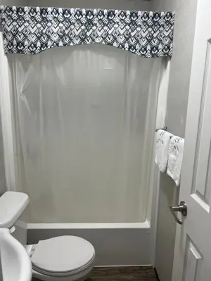 a bathroom with a toilet and a shower curtain at Cottage on Niagara on the Lake in Niagara on the Lake