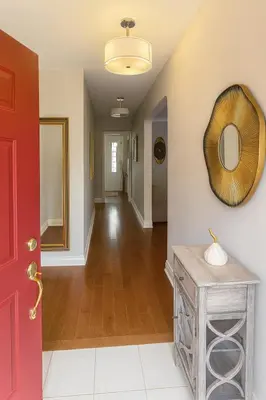 a hallway with a red door and a mirror at Spacious 5-Bedroom House in Thornhill in Vaughan