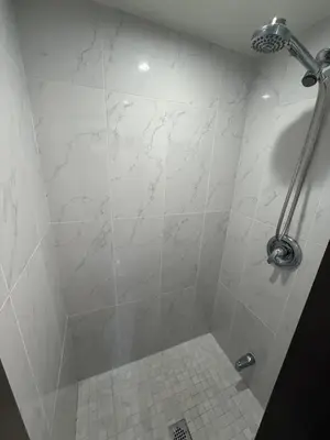 a bathroom with a shower with a white tiled floor at Spacious 5-Bedroom House in Thornhill in Vaughan