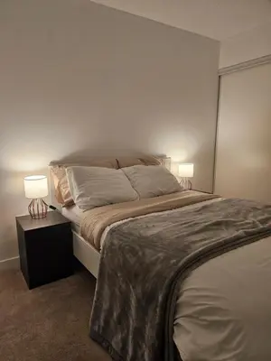 a bedroom with a large bed with two lamps at The Nest in Toronto