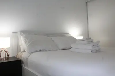 a white bed with white sheets and pillows at The Nest in Toronto