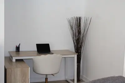 a desk with a laptop computer on it with a chair at The Nest in Toronto