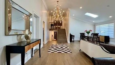a dining room and living room with a chandelier at Luxury 4BR Retreat with Pool, Piano, Spa & Games in Mississauga