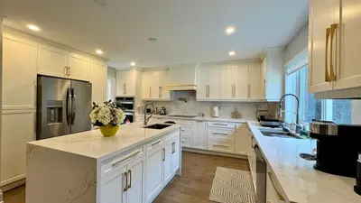 a large kitchen with white cabinets and a counter top at Luxury 4BR Retreat with Pool, Piano, Spa & Games in Mississauga