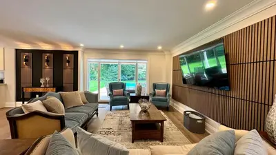 a large living room with couches and a tv at Luxury 4BR Retreat with Pool, Piano, Spa & Games in Mississauga