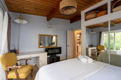 a bedroom with a bed and a desk and a television at 4 Bedroom Stoney Creek Nature Oasis Sauna, Games & Luxury Comfort in Hamilton